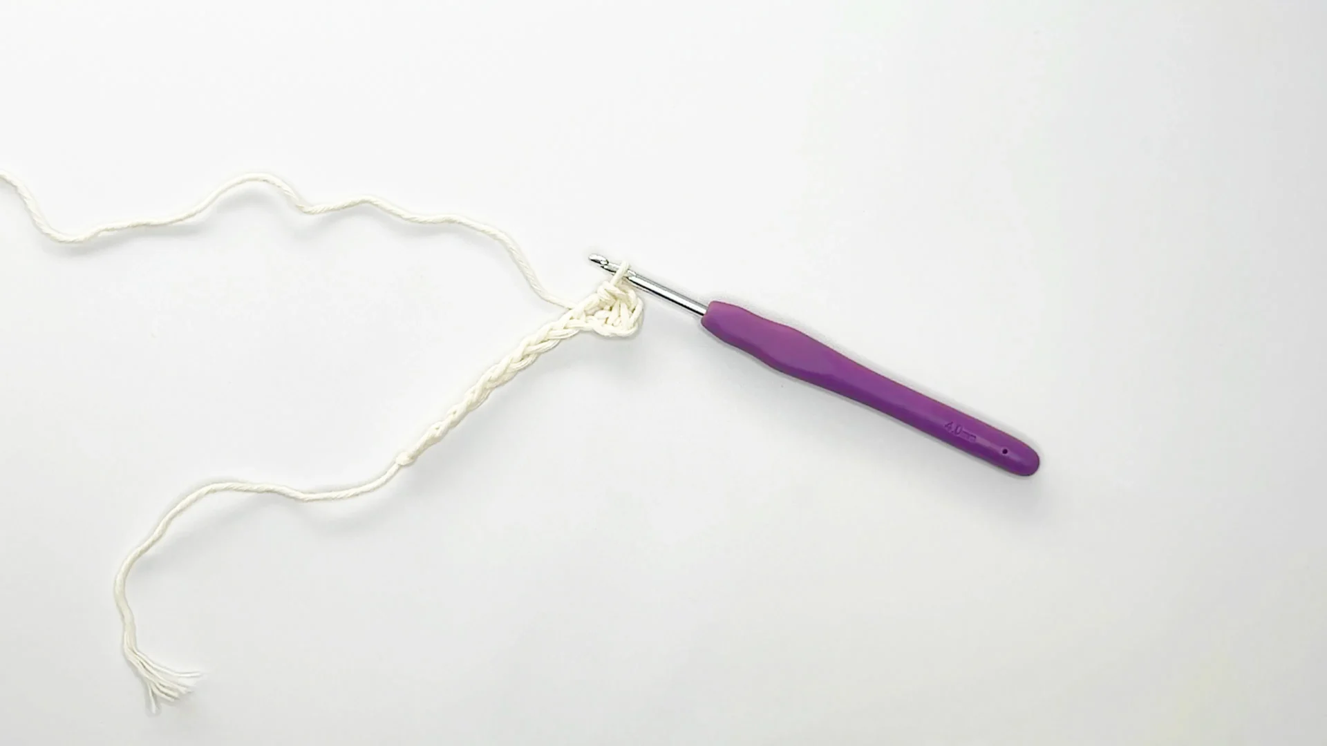 purple crochet hook and white yarn