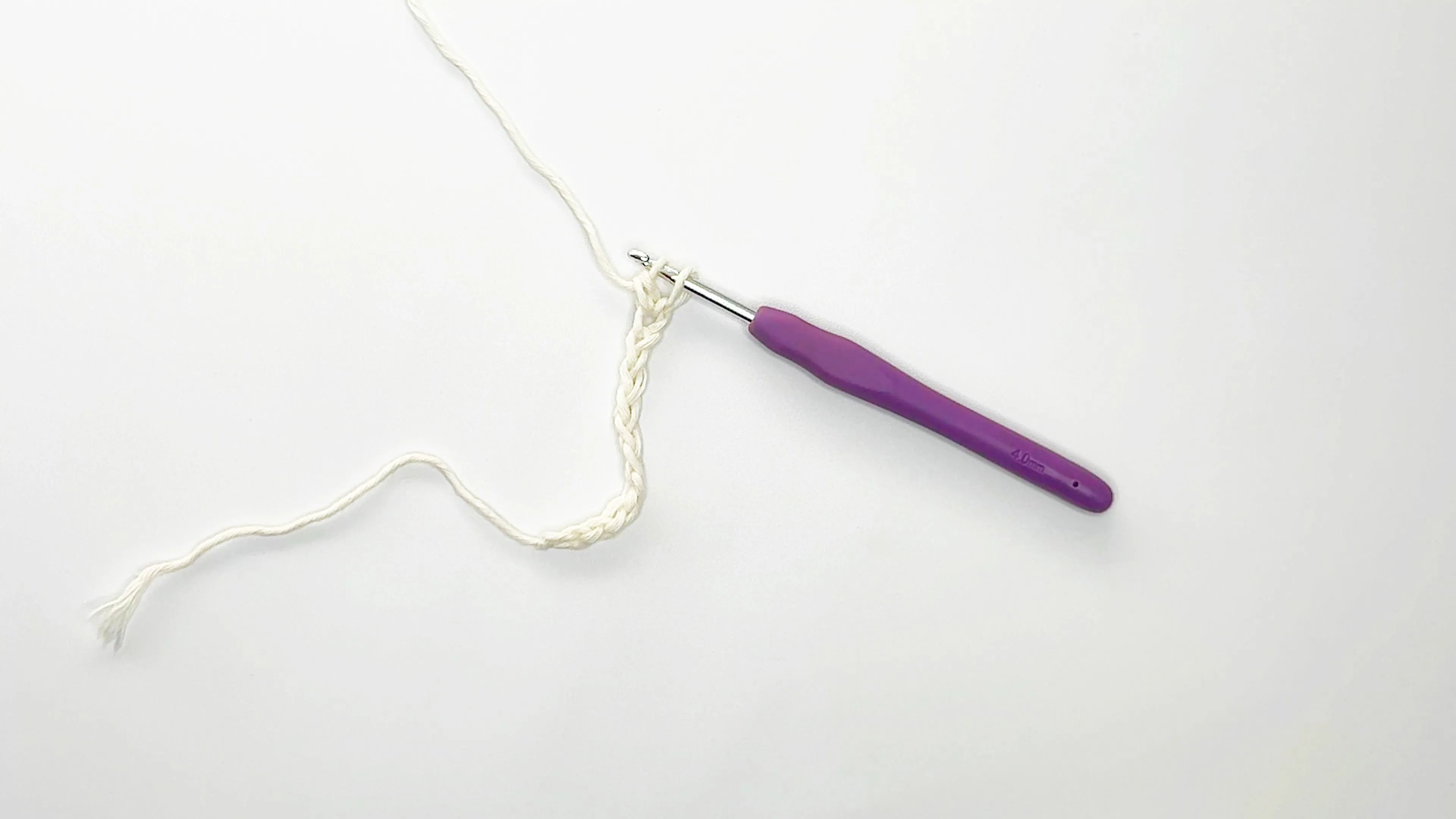 purple crochet hook and white yarn