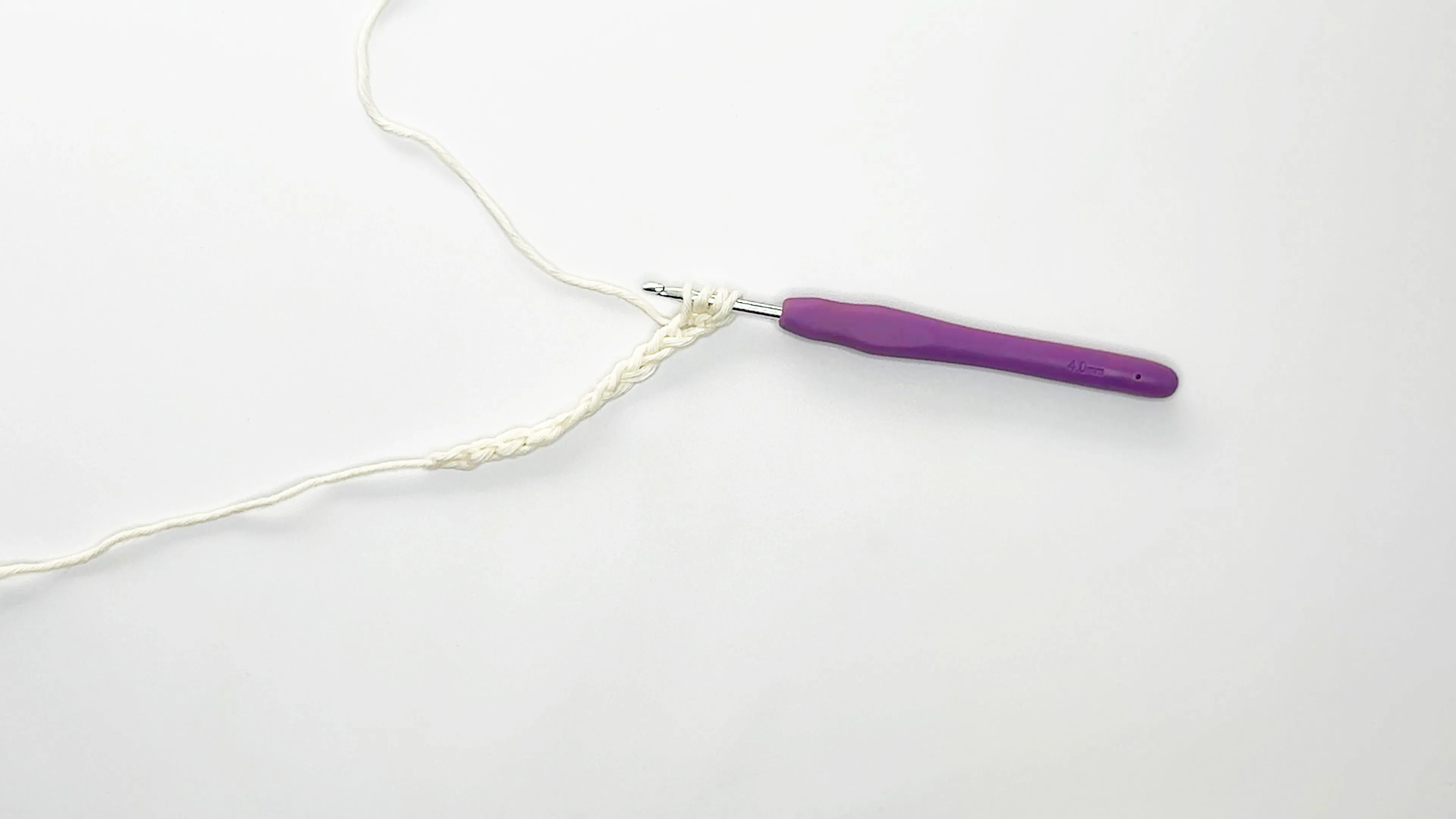 purple crochet hook and white yarn