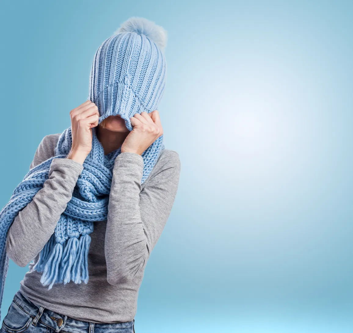 woman pulling crochet beanie over her head